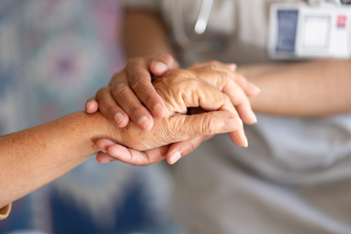 Patient hand held by a healthcare providers hand.
